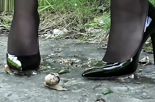 Lena crushing snails on every side her X-rated black heels.